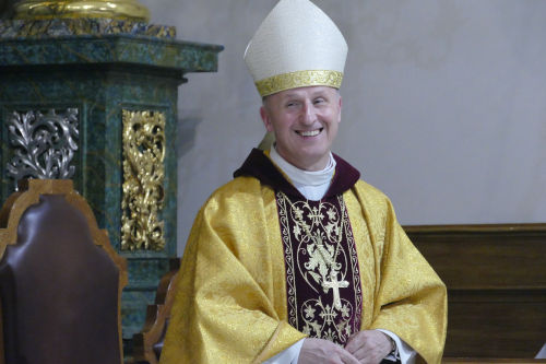 Uśmiechający się Ks. biskup Marek Solarczyk w złotym ornacie.