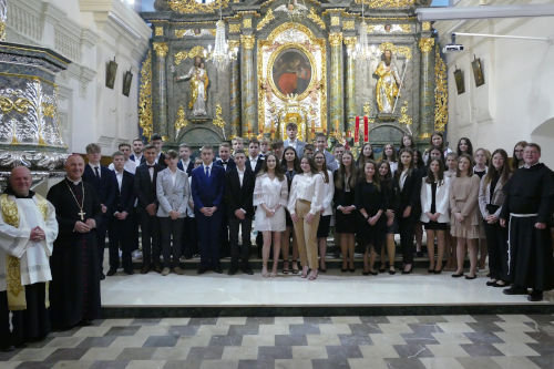 Bierzmowana młodzież stojąca przy Ołtarzu wraz z Kapłanami.