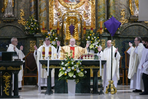 Pięciu Kapłanów odprawiających Mszę Świętą przy ołtarzu. Krzyże zasłonięte purpurowym nakryciem.