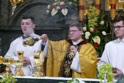 Kapłan okadzający ołtarz w asyście dwóch ministrantów.