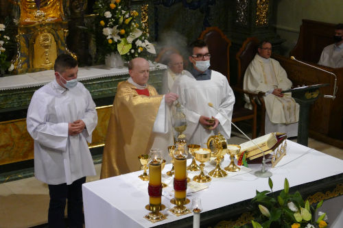 Kapłan okadzający ołtarz w asyście dwóch ministrantów.