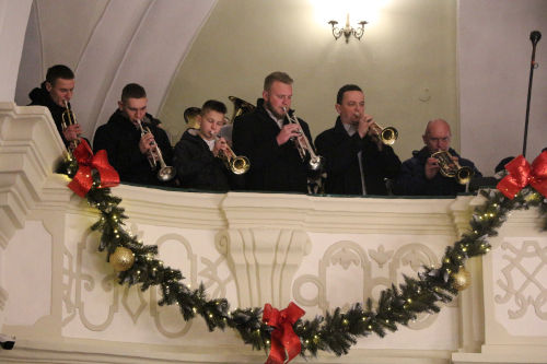 Sześciu mężczyzn na chórze grających na instrumentach dętych.